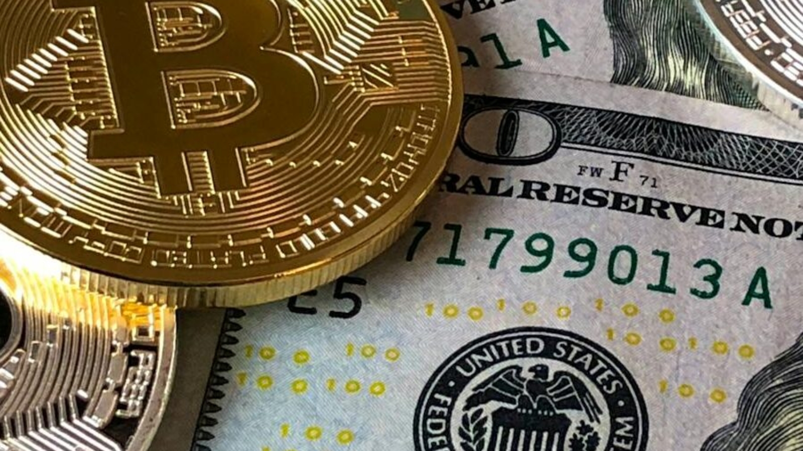 A close-up photo depicting Bitcoin coins on top of US dollar bills, symbolizing finance and cryptocurrency.